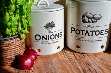 Kitchen worktop with ceramic pots for potatoes and onions.