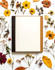 Flat lay of dried flowers and leaves around a notebook