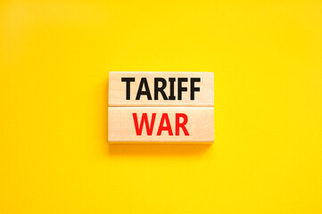 Naklejka premium Trade tariff war symbol. Concept word Tariff war on beautiful wooden blocks. Beautiful yellow paper background. Business trade tariff wars concept. Copy space.