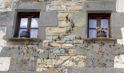 Traditional window in a stone house in the picturesque medieval village of Rupit. The window, with a wooden frame and white curtains. Rupit, Barcelona, ​​Spain