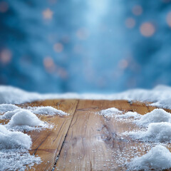 Wooden surface covered with snow with empty copy space for product placement with blurred dark blue frosty winter snowing background. Seasonal advertising, nature, winter concept.