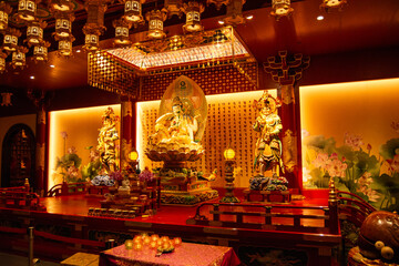 Ornate temple interior with deity statue and lanterns