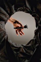Hand throwing a razor in to a rubbish bin, view from inside the bin