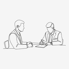 Two businessmen in suits at a table one writing on paper