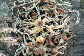 Intricate wooden sculpture with faces and branches
