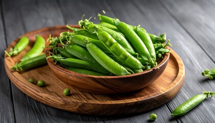 Fresh peas in a wooden bowl on a dark wooden surface