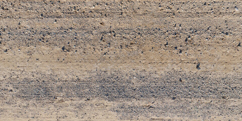 top view of gravel road surface with tractor tire tracks in countryside