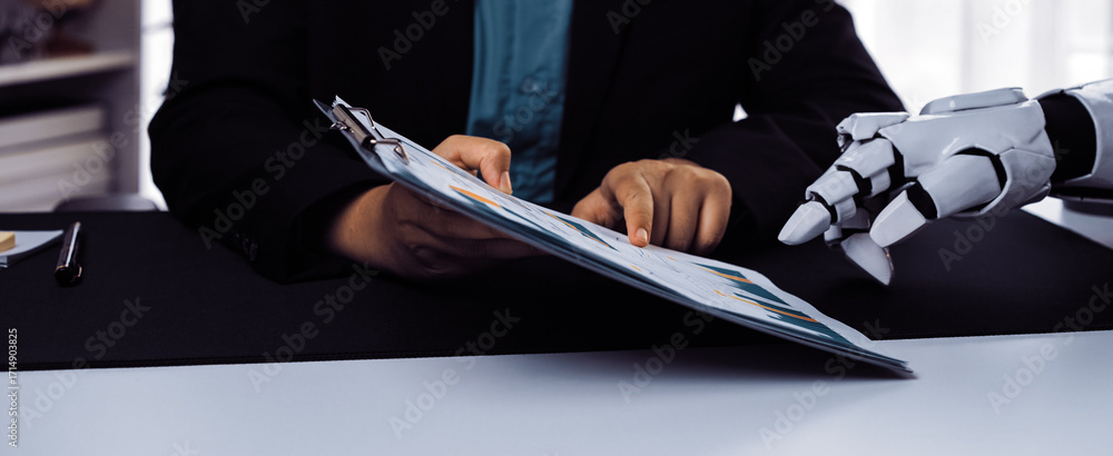Poster a human and a robotic hand collaborate over documents in a modern workspace, showcasing the integrat