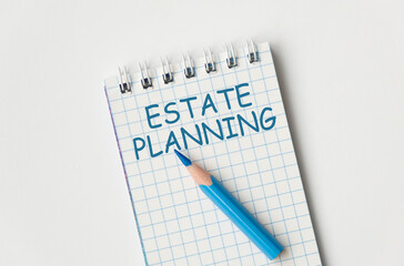 Estate Planning text on open notebook with blue pen on wite background