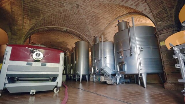 Factory interior with advanced technologies for high quality wine making, stainless tanks and processing machinery in warehouse with cool temperature, process of exclusive wine fermentation