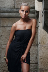 Elegant Woman Posing in Stylish Outfit in a Stone Wall Setting