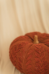 Textured fabric pumpkin on beige cloth with copy space