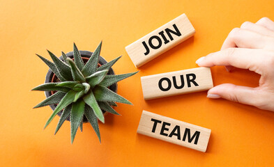Join our team symbol. Wooden blocks with words Join our team. Beautiful orange background with succulent plant. Businessman hand. Business and Join our team concept. Copy space.
