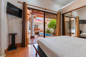 Stylish hotel room with direct pool access and tropical courtyard view