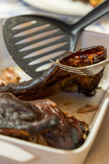 Traditional Sardinian suckling pig, artisanally cooked at home with potatoes on a family table.