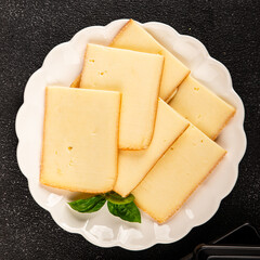 Raclette cheese portion slicing natural product tasty snack fresh delicious gourmet food background on the table rustic top view copy space