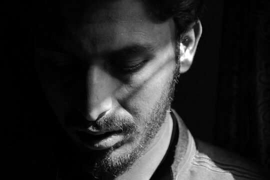Dramatic Black and White Portrait of a Young Man with Half Face Shadow Lighting

