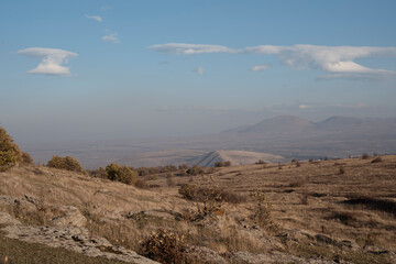 A landscape of arid mountains and vast open sky with Clouds. Autumn in Armenia