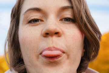 Playful Close-Up Portrait Of Young Woman Outdoors