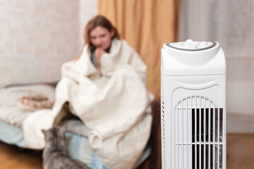 Electric Heater Warming Woman Wrapped In Blanket