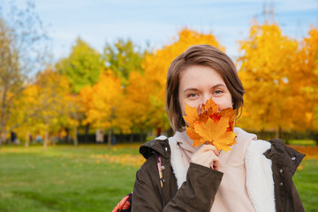 Woman Holding Autumn Leaves Near Face Outdoors