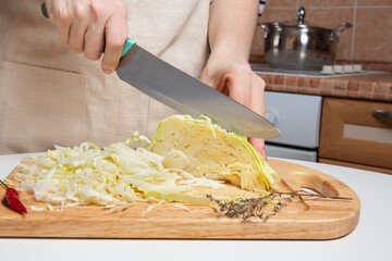 Domestic Chef Slicing Fresh Cabbage With Knife On Kitchen Board