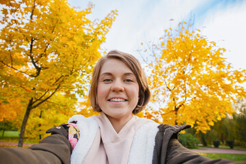 Young Woman Taking Selfie In Autumn Park