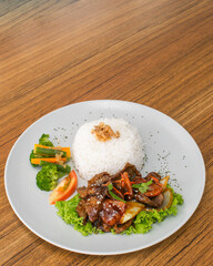 Delicious Asian dish with rice, meat, and vegetables on a plate.