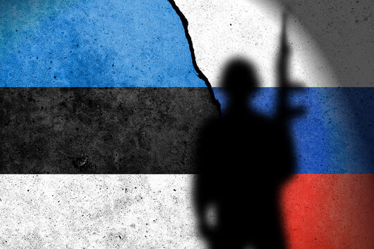 Flag of Estonia and Russia painted on a concrete wall with soldier shadow.