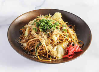 Fried Soba Noodles with Vegetables, Chicken, sliced bell peppers, and fresh scallions on a Plate side view of Japanese Cuisine