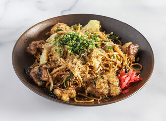 Japanese Offal Fried Noodles with Cabbage and Pickled Ginger on a Dark Plate side view of Japanese food
