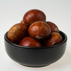 Obraz premium Pile of chestnuts in a black bowl