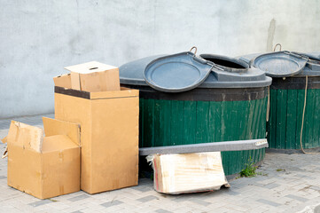 Cardboard boxes left near underground waste containers for recycling