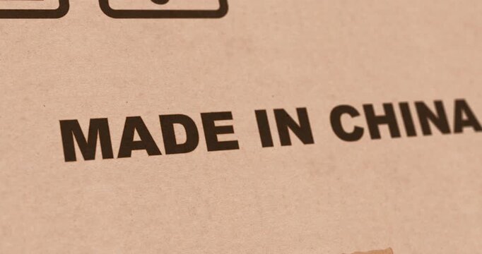 Made in China, stamp on cardboard package box, close up zoom, produced in China mark, footage