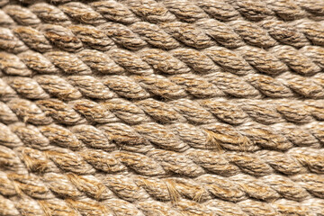 Close-up of twisted natural fiber rope with a textured surface. The rope is light brown and shows intricate details of the fibers.