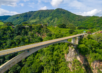 Fototapeta premium Vista aérea de puente de arco de concreto cruzando cañón verde y montañas en la carretera a San Sebastián del Oeste