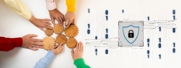 A group of diverse hands work together on wooden gears, symbolizing collaboration in cybersecurity,...