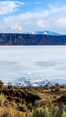 Panoramic view of a frozen lake, mountains in the background