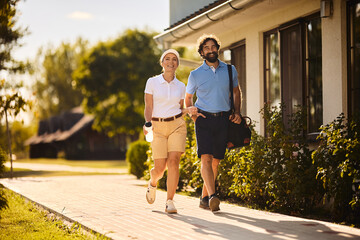 Fototapeta premium Happy golfing couple walking to golf course.