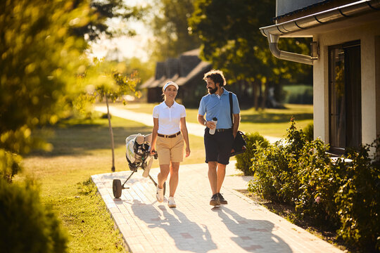 Full length of happy couple at golf club. - Powered by Adobe