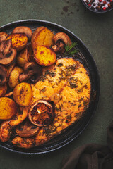 Delicious dinner with roasted salmon, baby potatoes and mushrooms, green table background, top view