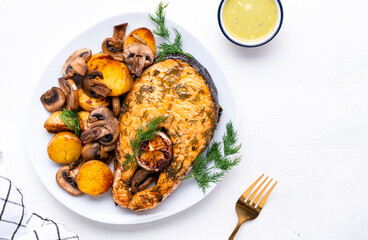 Yummy dinner with grilled salmon, baby potatoes and mushrooms with creamy garlic sauce on white table, top view