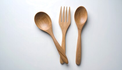 Wooden spoons and fork on white surface