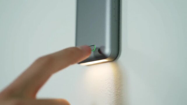 User Activates Modern Smart Home Device by Pressing a Touch-Sensitive Button with Green LED Feedback