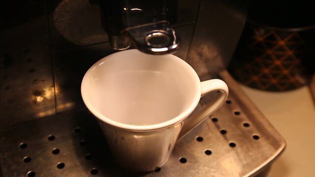 Coffee machine pours coffee into a cup with natural sound. Espresso coffee maker filling a cup