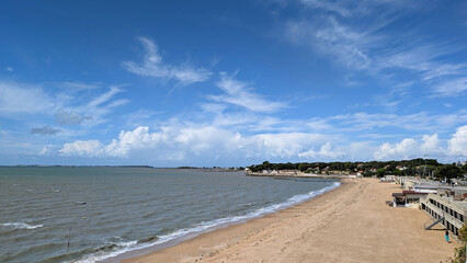 Scenic view of Fouras, France, with sandy beach, ocean and coastal town in the background. 