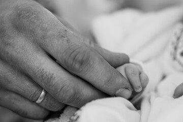 Loving Father's Touch: Black and White Close-Up of Hand Holding Newborn Baby Foot, Gentle Care, Parenthood, Texture, Monochrome