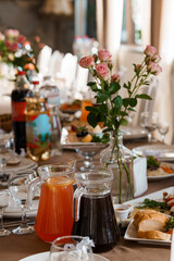 Elegant Wedding Table Setting with Roses, Drinks, and Food. Warm Light, Rustic Decor, Celebration Event, Beige and Pink Tones, Fine Dining.
