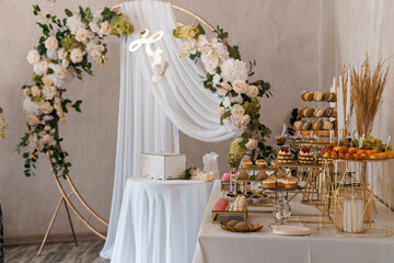 Elegant Wedding Dessert Table Setup with Floral Arch and 