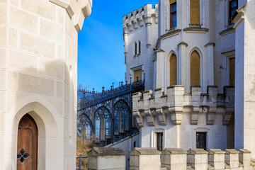 Majestic medieval castle with stone towers and iron bridge under blue sky